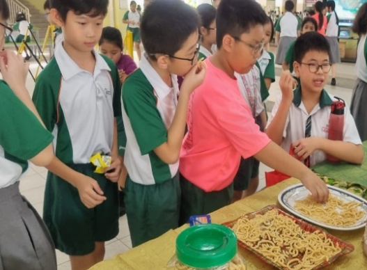 Students exploring traditional snacks during a Tamil cultural learning activity.